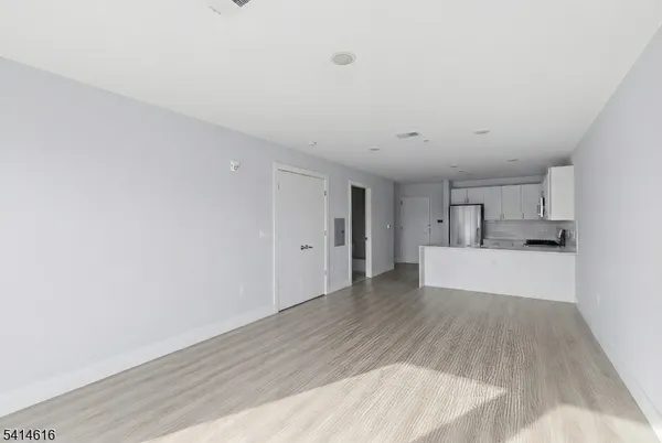 a view of a kitchen with wooden floor and a sink