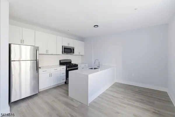 a kitchen with stainless steel appliances a refrigerator sink and microwave