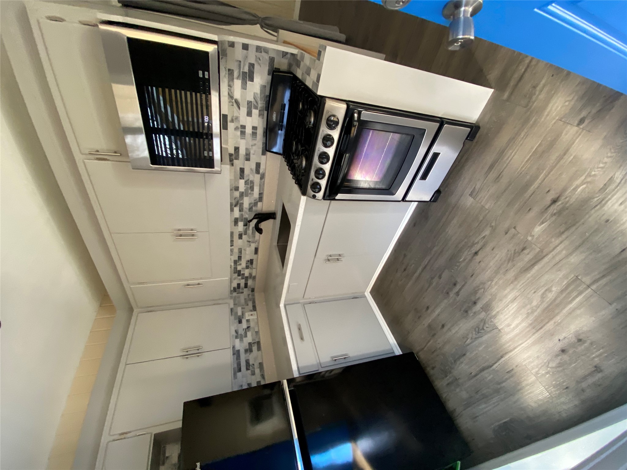 3010 Fruth Street, Unit B Austin, TX 78705 - Photo 19 of 32 A compact culinary space features modern appliances and stylish backsplash, blending functionality with visual appeal.