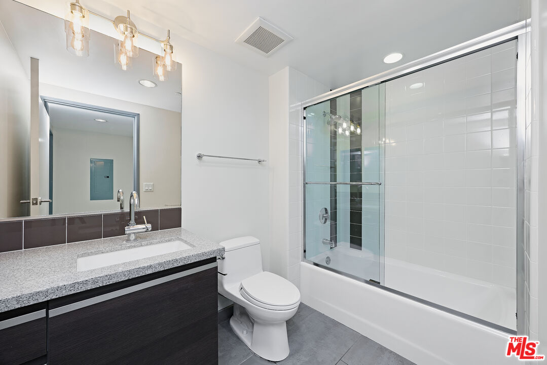 3119 Vía Dolce, Unit 302 Marina del Rey, CA 90292 - Photo 16 of 27 a bathroom with a granite countertop sink toilet and shower