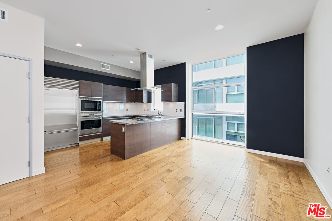 3119 Vía Dolce, Unit 302 Marina del Rey, CA 90292 - Photo 25 of 27 a kitchen with stainless steel appliances kitchen island granite countertop a refrigerator and a sink