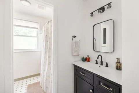 a bathroom with a sink vanity and a mirror