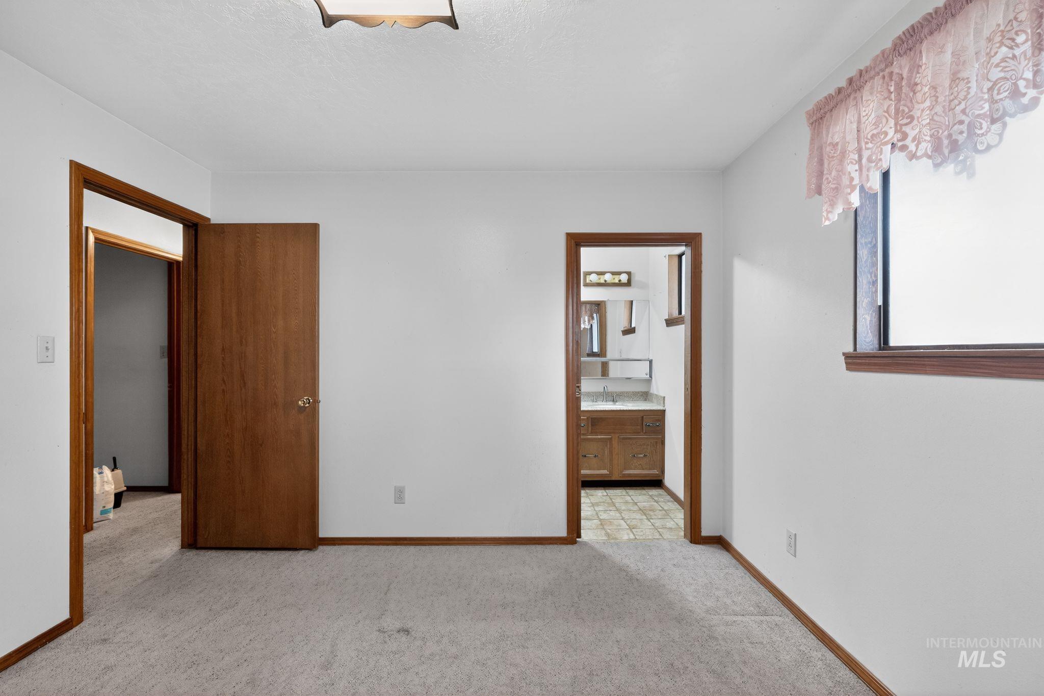 1055 South Adell Street Filer, ID 83328 - Photo 21 of 28 Unfurnished bedroom with light colored carpet and connected bathroom