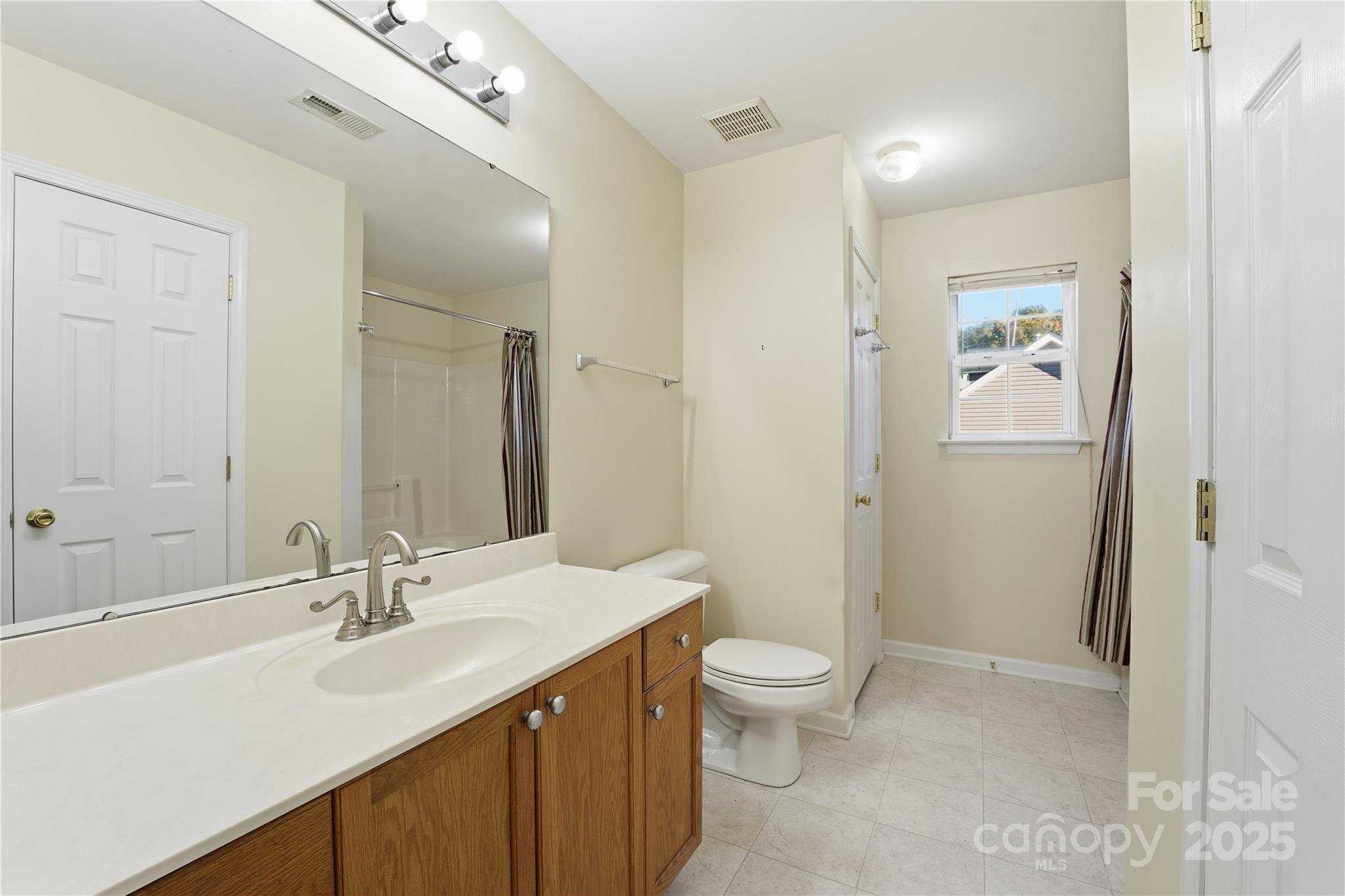 5822 Meeting Street Concord, NC 28025 - Photo 12 of 21 a bathroom with a double vanity sink toilet and shower