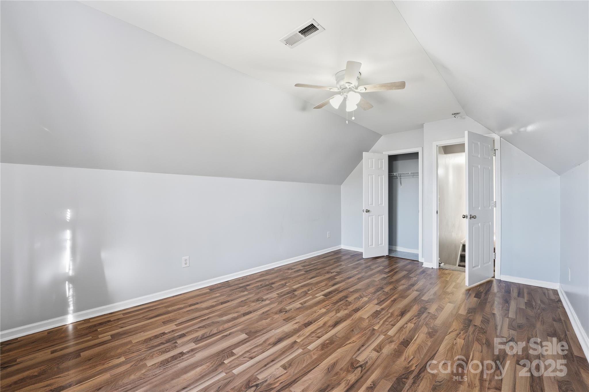 5822 Meeting Street Concord, NC 28025 - Photo 18 of 21 a view of an empty room with wooden floor and a ceiling fan