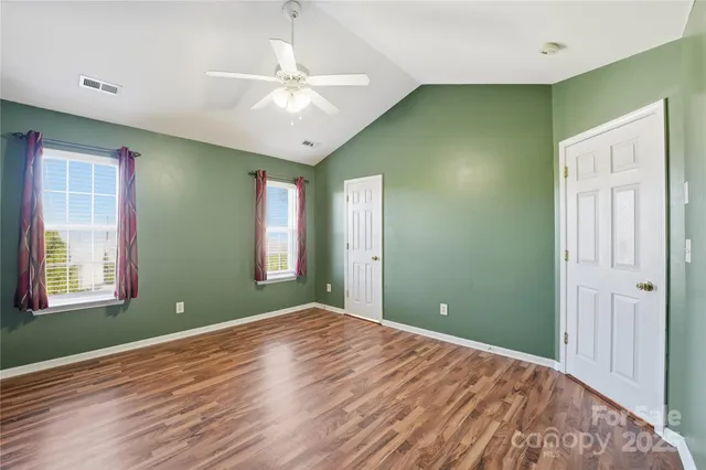 a view of empty room with window and ceiling fan
