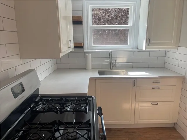 a kitchen with white cabinets and a stove