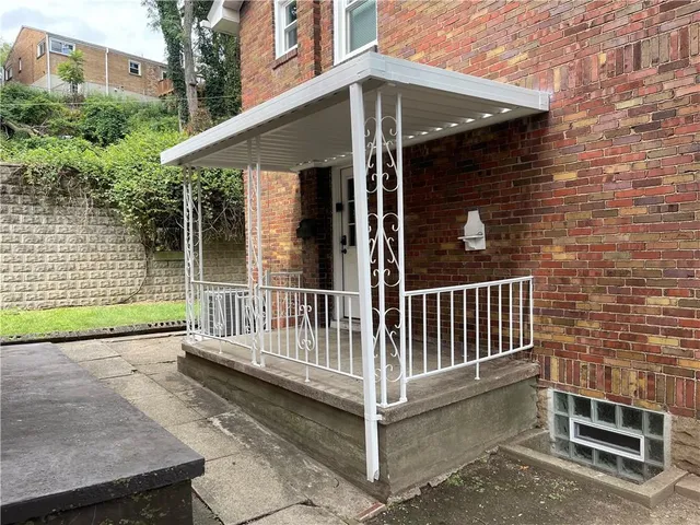 a view of a house with a small yard and wooden fence and a large window