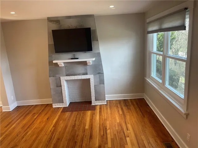 a view of a room with wooden floor and flat screen tv