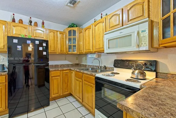 a kitchen with stainless steel appliances granite countertop a refrigerator stove and sink