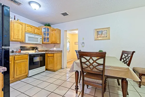 a kitchen with a table chairs sink and cabinets