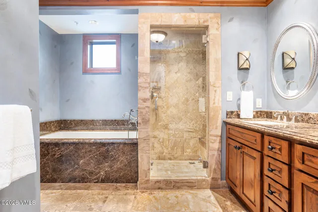 a bathroom with a granite countertop sink a mirror and a shower