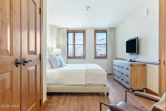 a bedroom with a bed and a flat tv screen on dresser