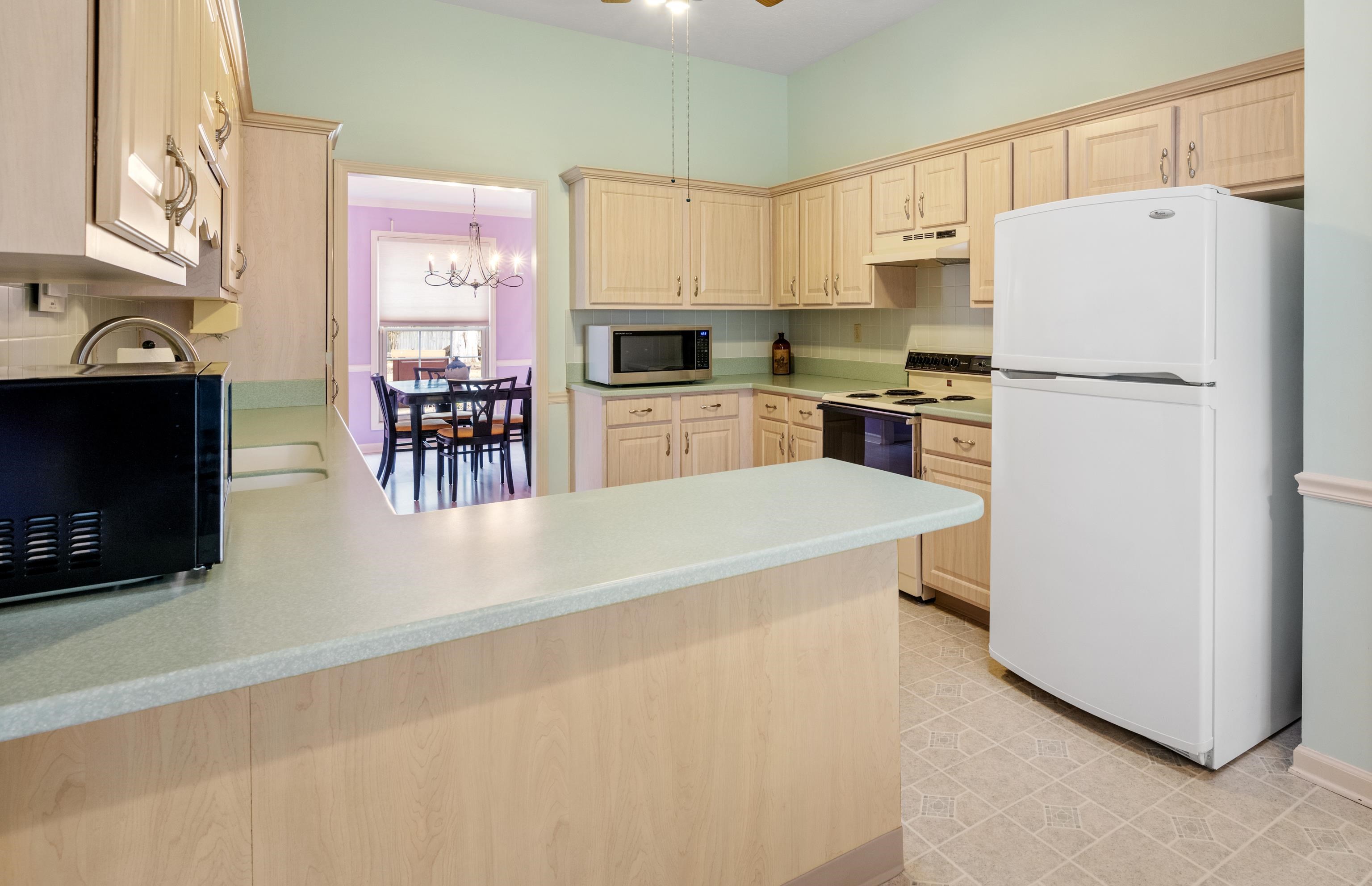 811 Vaughn Road Memphis, TN 38122 - Photo 11 of 33 a kitchen with granite countertop a refrigerator a stove a sink a dining table and chairs with wooden floor