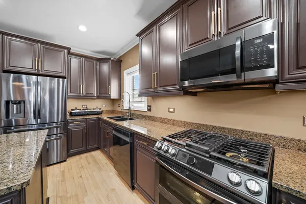 a kitchen with stainless steel appliances granite countertop a stove microwave sink and refrigerator