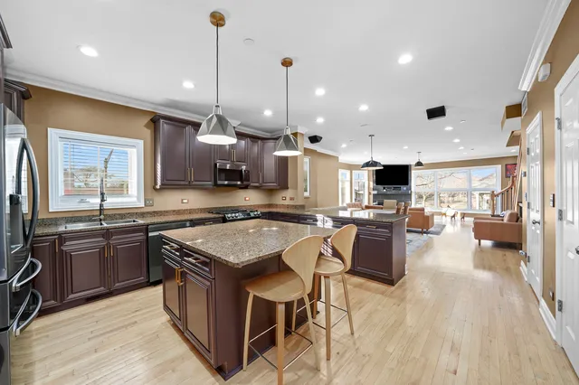 a kitchen with stainless steel appliances granite countertop wooden cabinets sink stove and a granite counter top