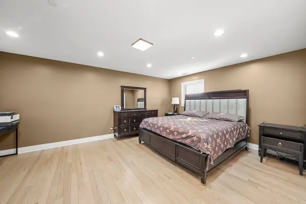 a spacious bedroom with a bed and a chair