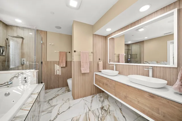 a bathroom with a double vanity sink a mirror and a bathtub