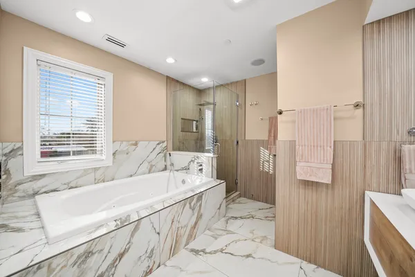 a spacious bathroom with a tub shower and a sink