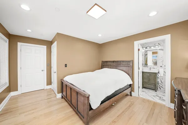 a bedroom with a large bed and a chandelier