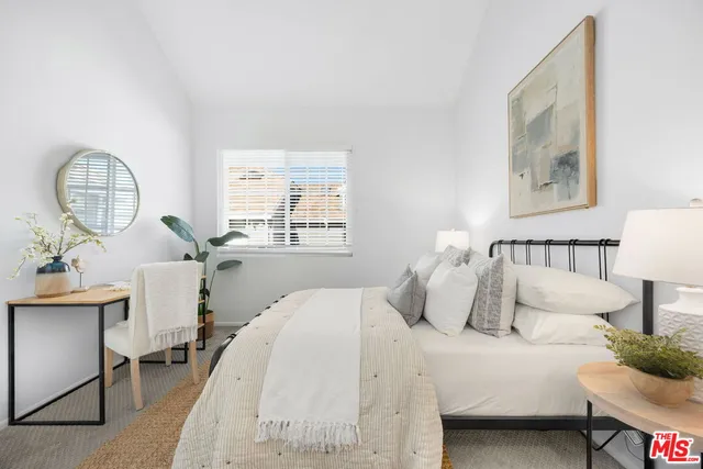 a bedroom with a bed a mirror and a window with outer view