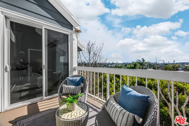 a view of a chair and tables on the balcony