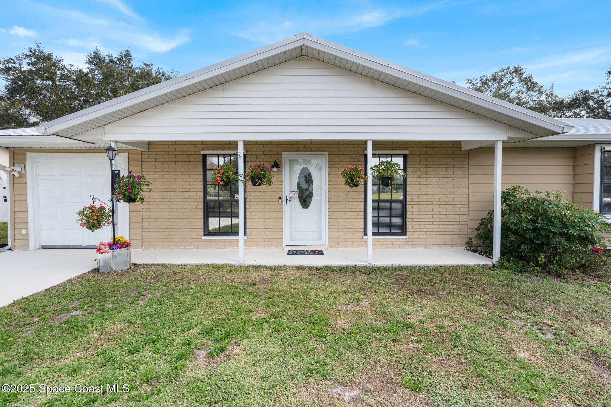 1550 Creel Road Northeast Palm Bay, FL 32905 - Photo 1 of 27 a front view of a house with a yard and garage