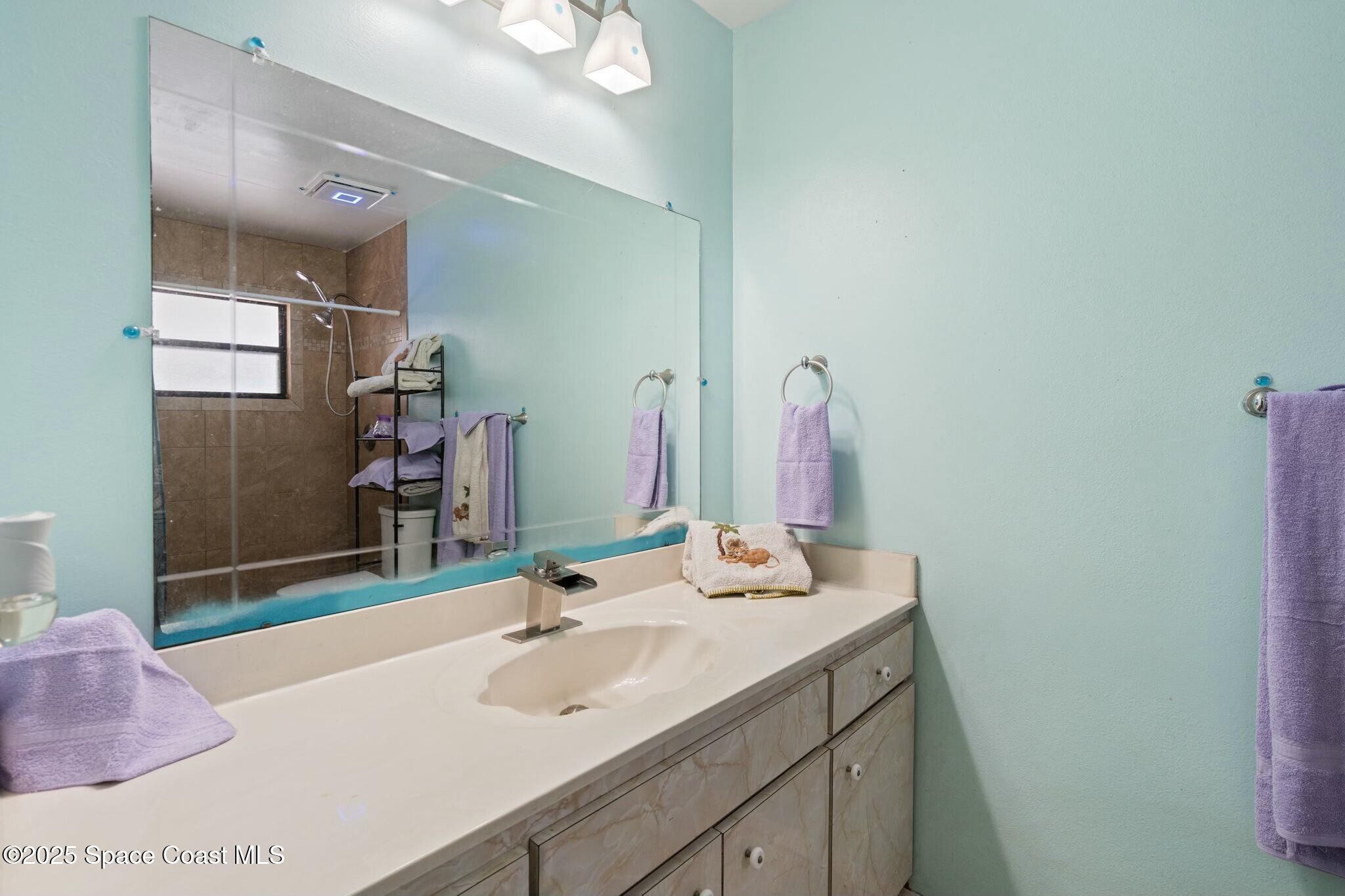 1550 Creel Road Northeast Palm Bay, FL 32905 - Photo 11 of 27 a bathroom with a sink and a mirror