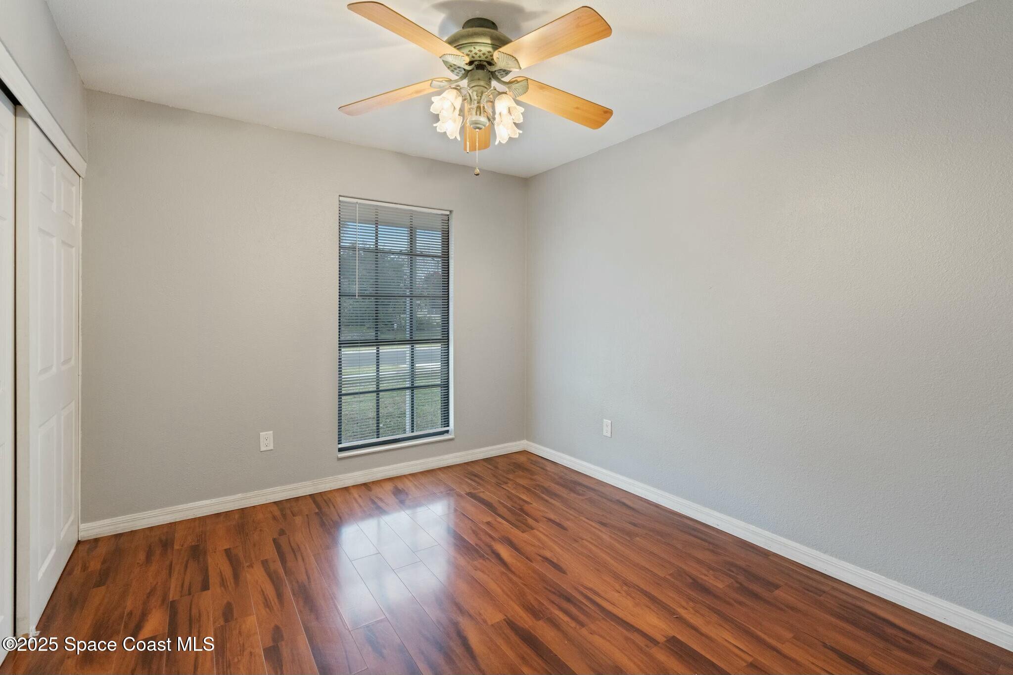 1550 Creel Road Northeast Palm Bay, FL 32905 - Photo 14 of 27 wooden floor in an empty room with a window