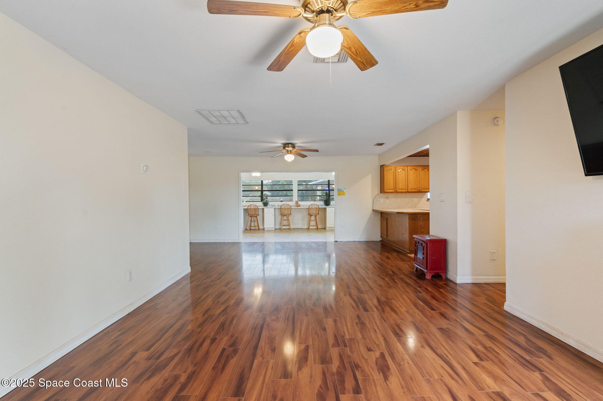 1550 Creel Road Northeast Palm Bay, FL 32905 - Photo 4 of 27 a view of empty room with wooden floor and fan