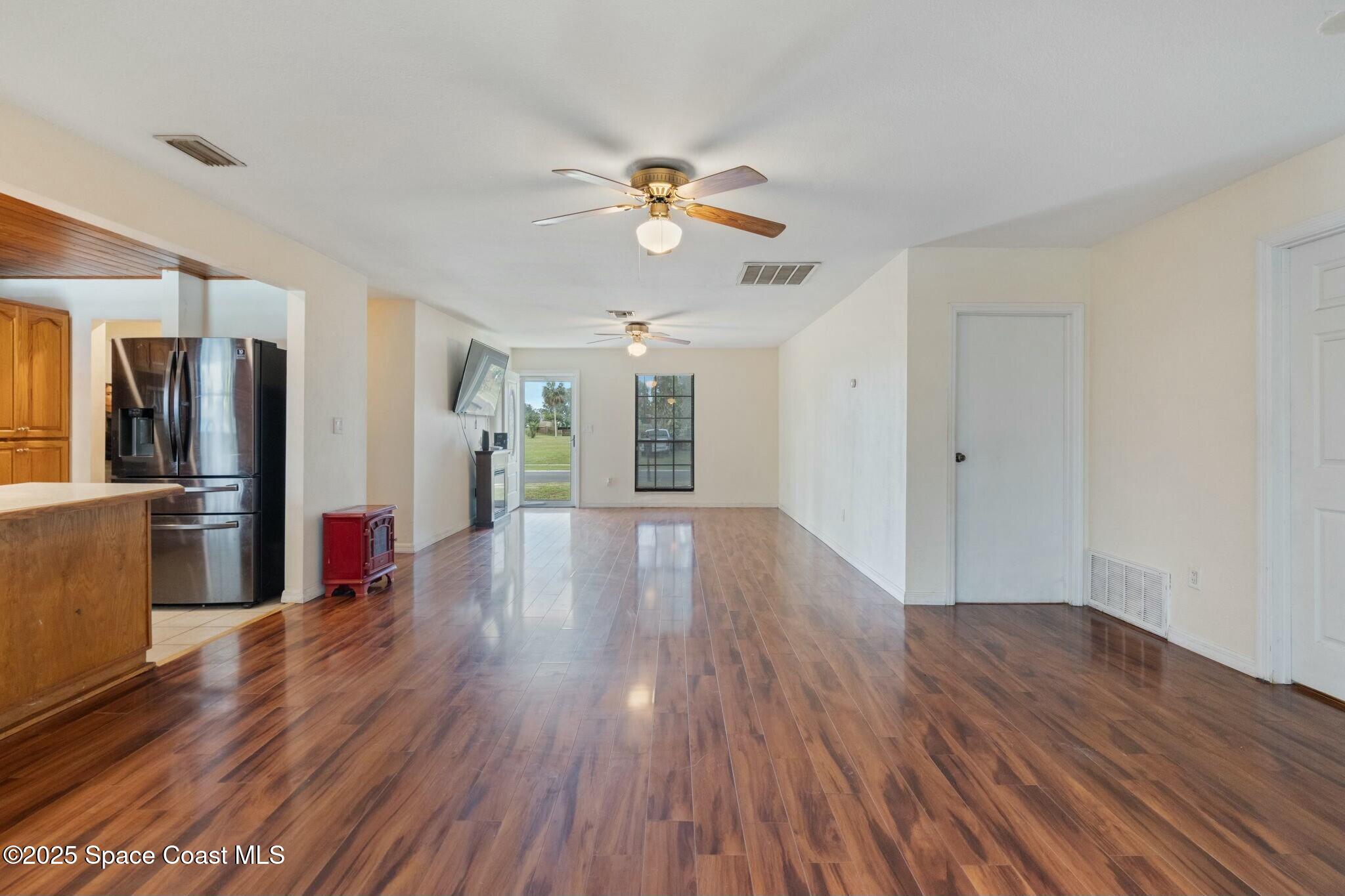 1550 Creel Road Northeast Palm Bay, FL 32905 - Photo 5 of 27 a view of a kitchen with wooden floor and a ceiling fan