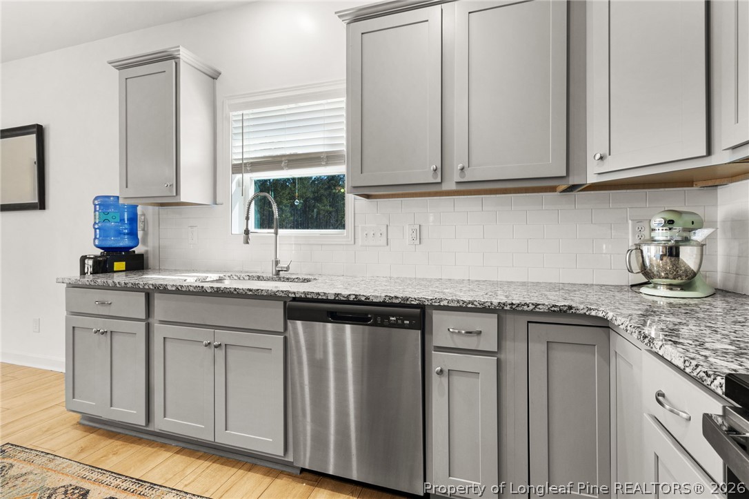 84 Rainy Beck Way Erwin, NC 28339 - Photo 11 of 36 a kitchen with granite countertop stainless steel appliances white cabinets sink and dishwasher