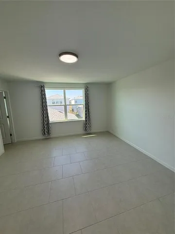 an empty room with window and mirror