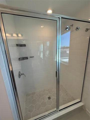 a bathroom with a shower and a glass door