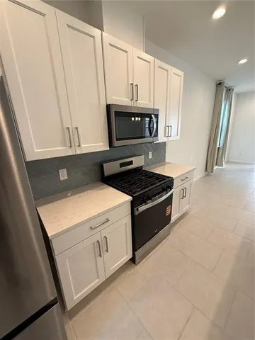 a kitchen with stainless steel appliances a stove microwave and sink