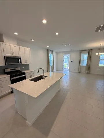 a large kitchen with stainless steel appliances lots of counter space and a sink