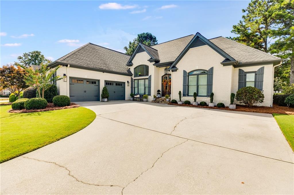a front view of a house with a yard and potted plants