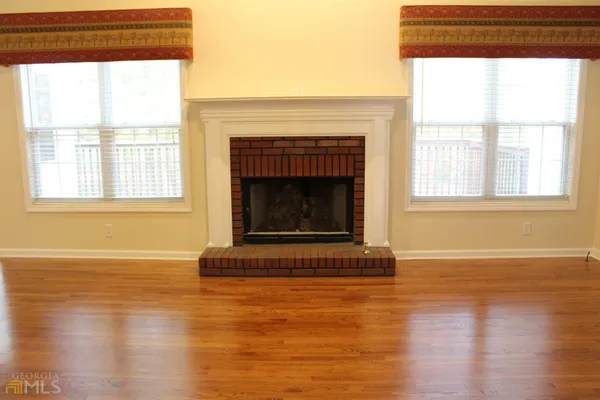 a living room with a fireplace and wooden floor