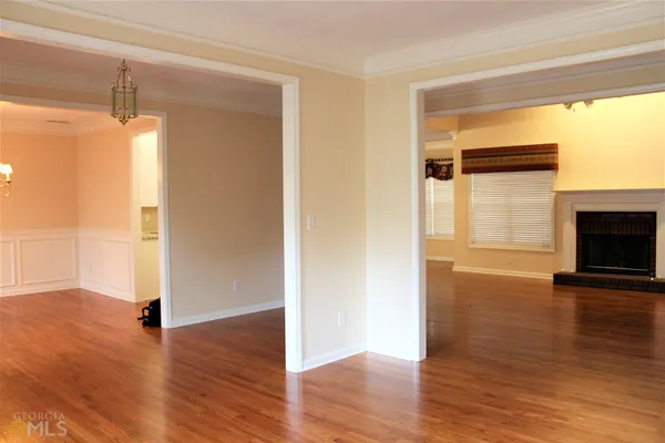 a view of empty room with wooden floor and fireplace