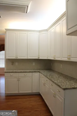 a kitchen with granite countertop white cabinets and a sink
