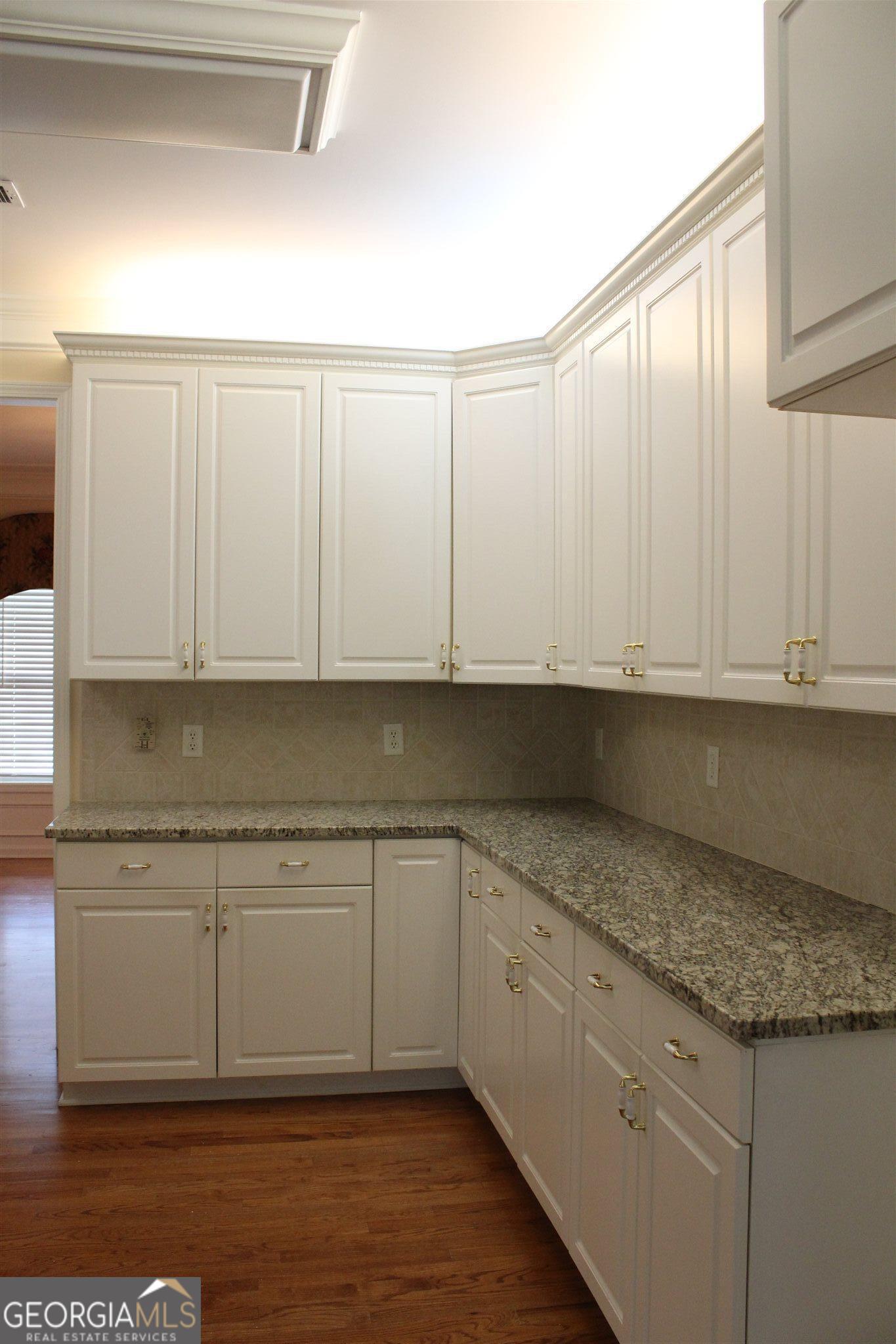 149 Walnut Ridge Drive Hoschton, GA 30548 - Photo 4 of 19 a kitchen with granite countertop white cabinets and a sink