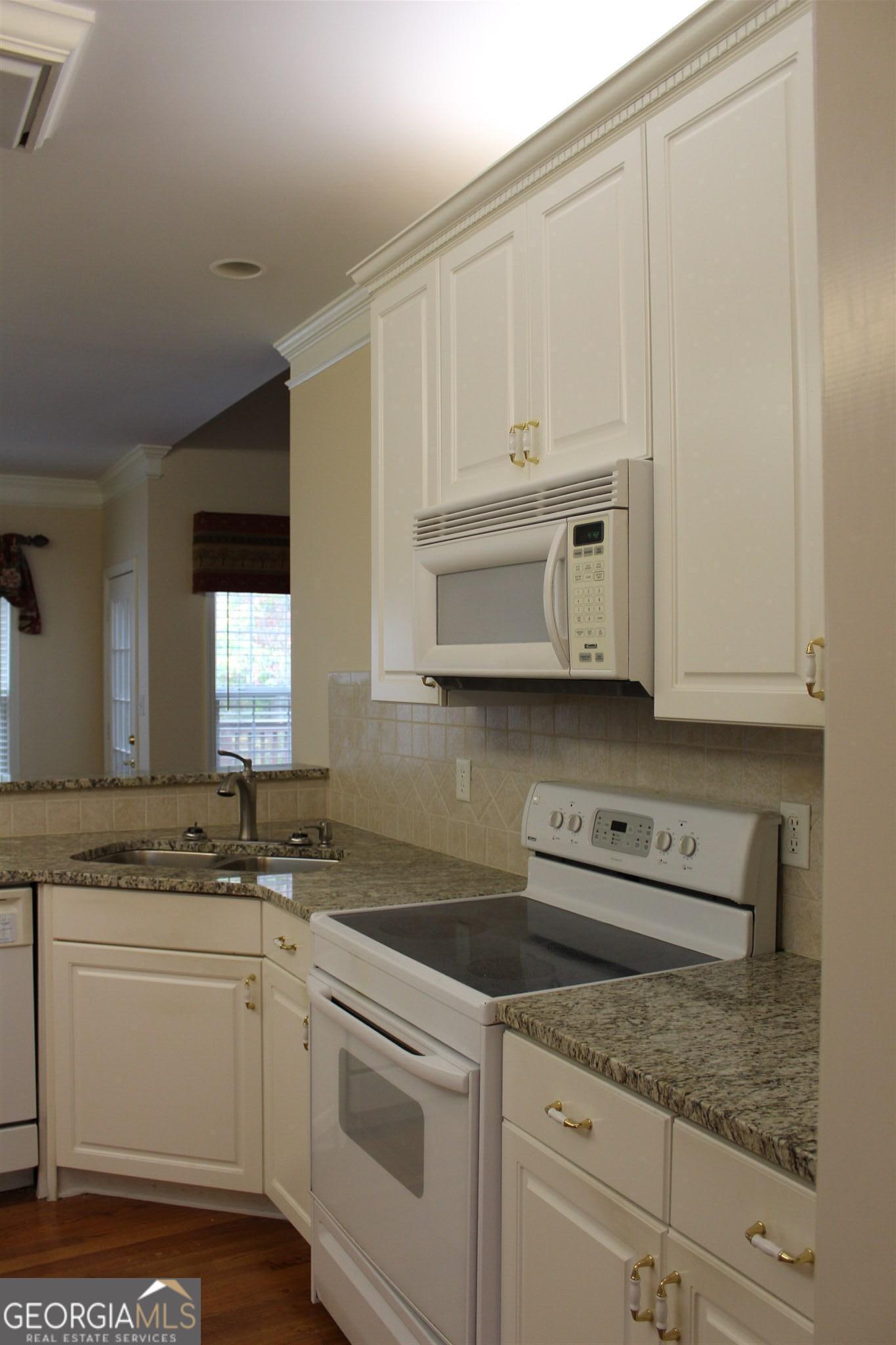 149 Walnut Ridge Drive Hoschton, GA 30548 - Photo 6 of 19 a kitchen with stainless steel appliances granite countertop a sink stove and cabinets