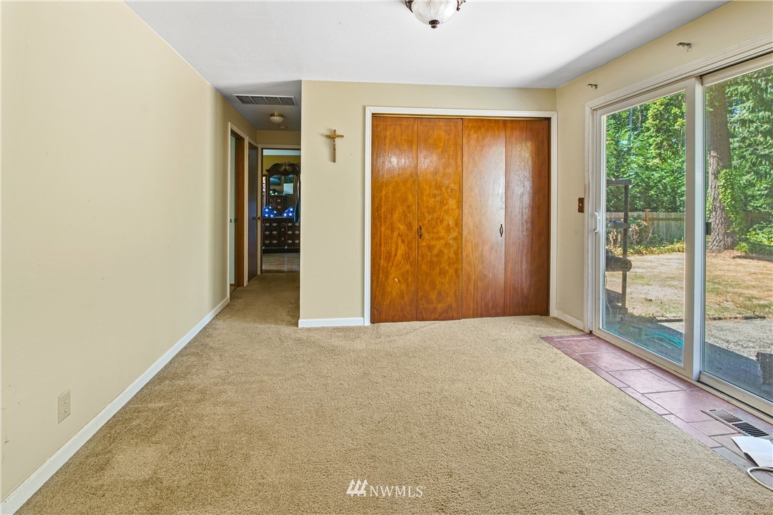 4117 212th Street Southeast Bothell, WA 98021 - Photo 11 of 32 an empty room with sliding door and wooden floor