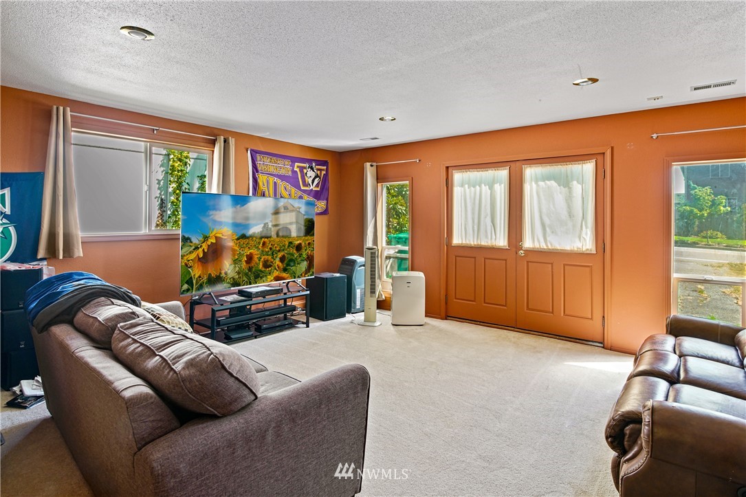 4117 212th Street Southeast Bothell, WA 98021 - Photo 12 of 32 a living room with furniture a flat screen tv and a large window