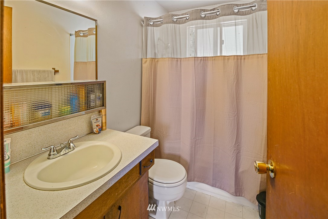 4117 212th Street Southeast Bothell, WA 98021 - Photo 15 of 32 a bathroom with a sink a toilet and shower curtain