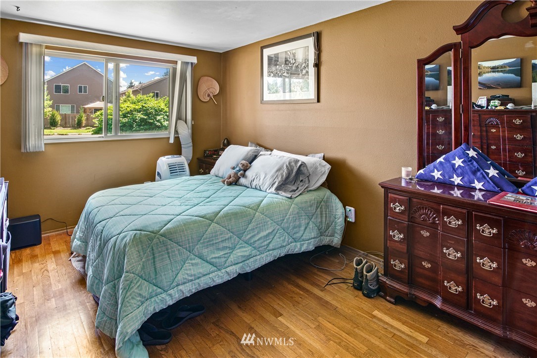 4117 212th Street Southeast Bothell, WA 98021 - Photo 18 of 32 a bedroom with a bed painting on wall and a large window