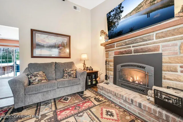 a kitchen with stainless steel appliances kitchen island granite countertop a refrigerator a stove a sink a dining table and chairs with wooden floor