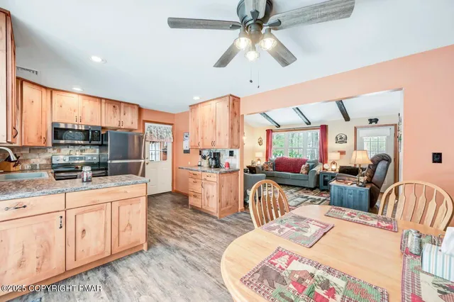 a view of a dining room and livingroom with furniture wooden floor and a clock