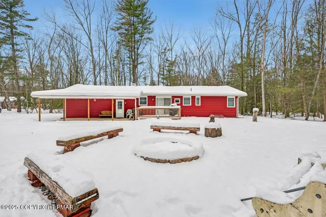 a living room with furniture a fireplace and a floor to ceiling window