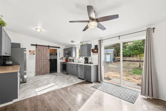 a kitchen with stainless steel appliances kitchen island granite countertop a refrigerator and microwave